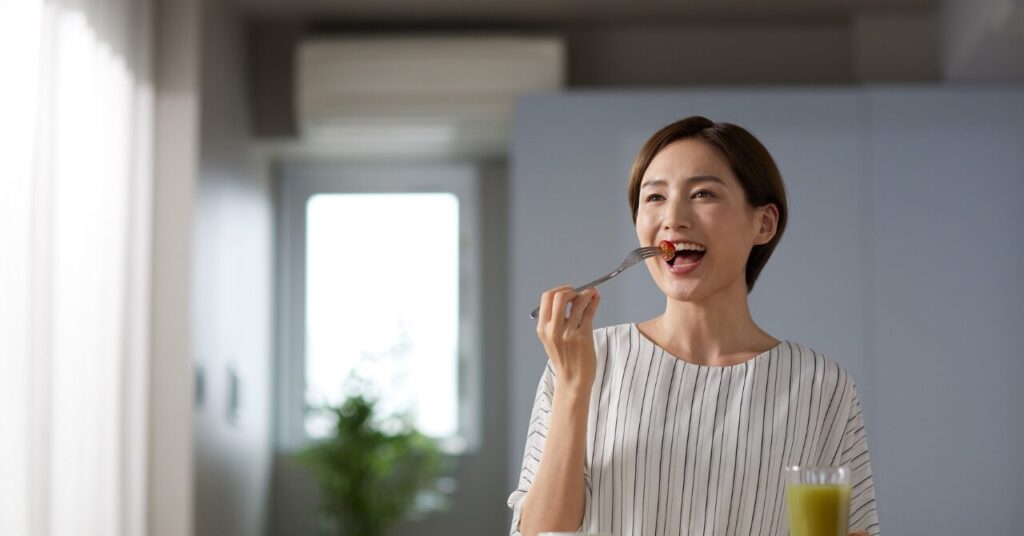 黄金比の料理をおいしそうに楽しく食事する女性